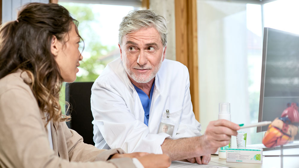 Doctor in consultation with patients sitting in office