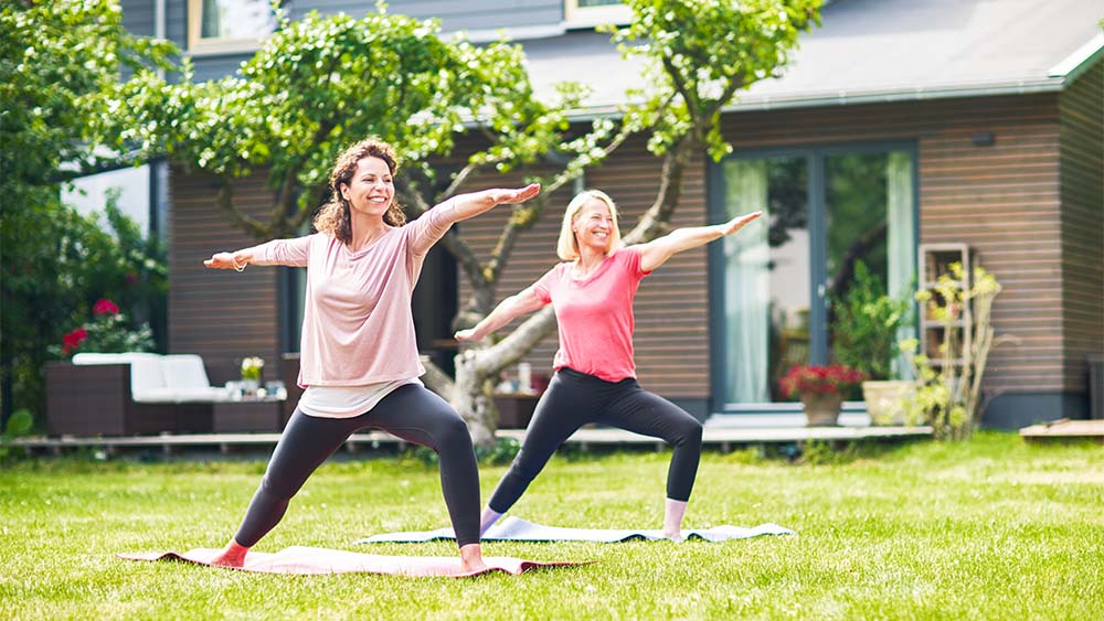 Two women doing yoga in the garden